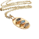 Golden necklace oval pendant trilogy of stones