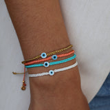 Bracelet doré cordon tressé corail oeil blanc plat