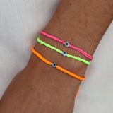 Bracelet doré cordon tressé jaune fluo oeil blanc