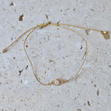 Bracelet tressé doré et oeil zircon blanc