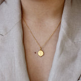 Collier doré médaille texturée et croix