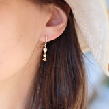 Boucles d'oreilles dorées barre en zircons blancs avec pampilles