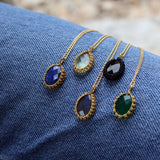 Gold necklace with stone pendant and woven thread