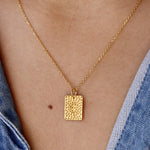 Collier doré plaque texturée et croix