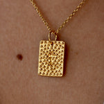 Collier doré plaque texturée et croix