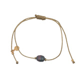 Gold bracelet and gray cultured pearl