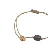 Gold bracelet and gray cultured pearl