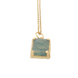 Gold necklace with textured pendant and rectangular stone