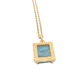 Gold necklace with textured pendant and rectangular stone