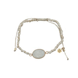 Bracelet cordon crème avec pierre de lune ovale cerclée de doré