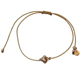 Gold cord bracelet and mother-of-pearl clover