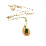 Gold necklace with textured oval pendant and stone