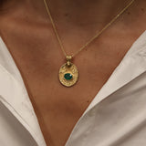 Gold necklace with engraved flower and stone pendant