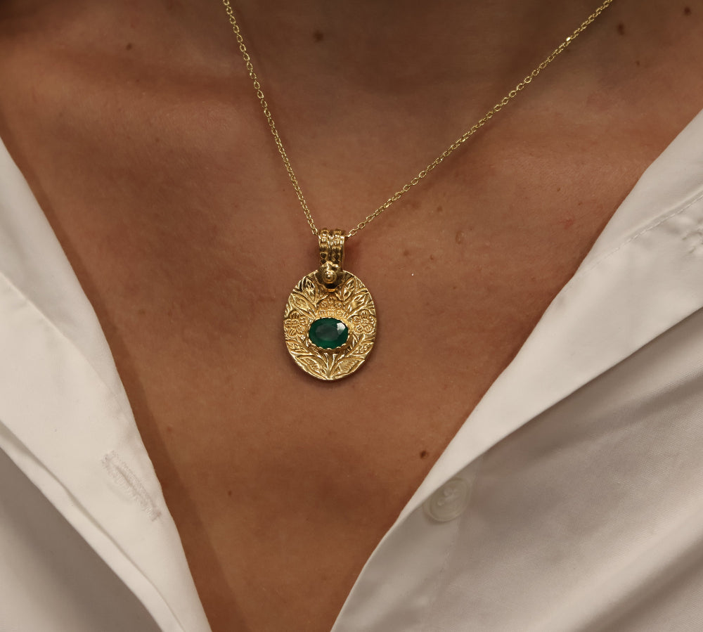 Gold necklace with engraved flower and stone pendant