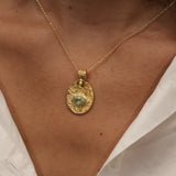 Gold necklace with engraved flower and stone pendant