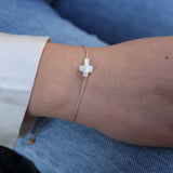 Beige thread bracelet and mother-of-pearl cross