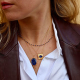 Gold necklace with textured square pendant and stone eye