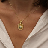 Gold necklace with engraved flower and stone pendant