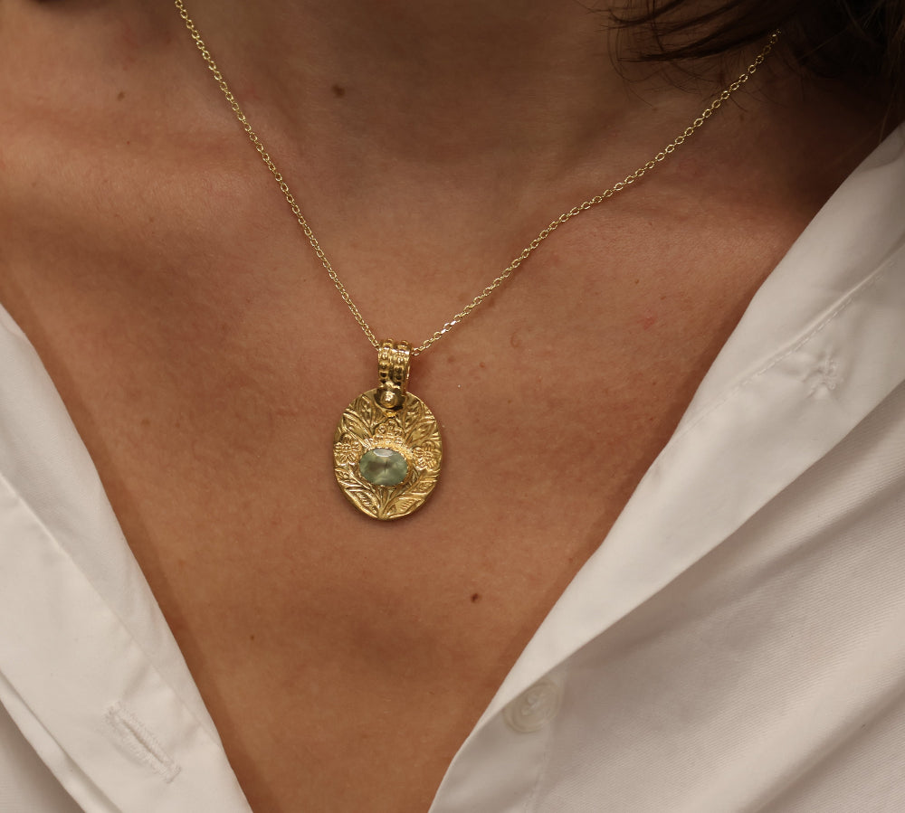 Gold necklace with engraved flower and stone pendant