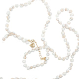 Collier doré perles blanches marbrées roses avec noeuds blancs 75 cm