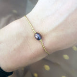 Bracelet doré avec perle de culture grise