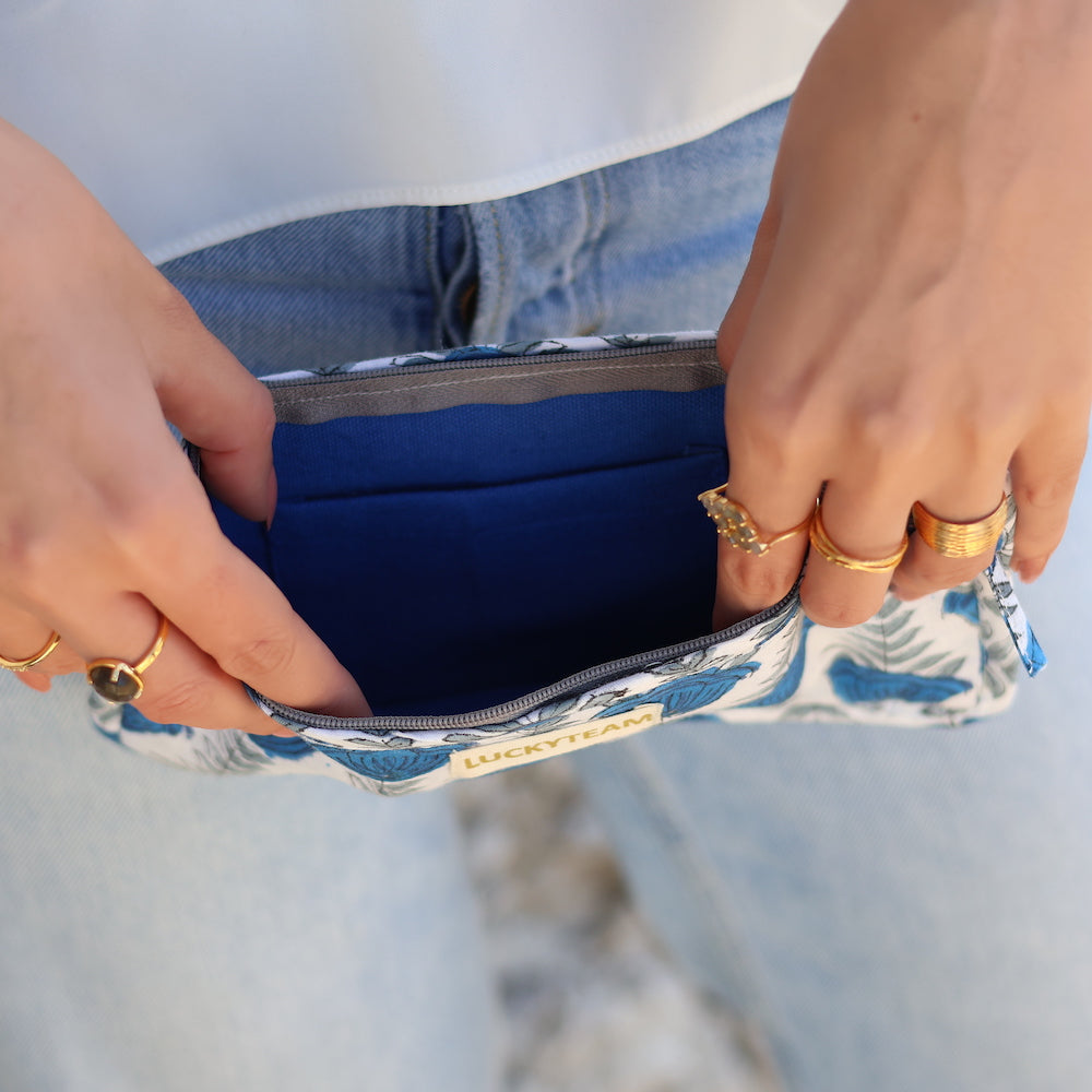 Pochette de voyage blanche et fleurs bleues