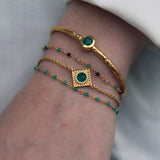 Golden square bracelet with round stone and zircons