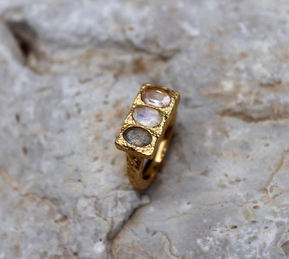 Hammered gold ring with trilogy of stones