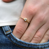 Golden ring with round stone and zircons