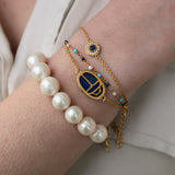Golden bracelet with small round stone and zircon medal