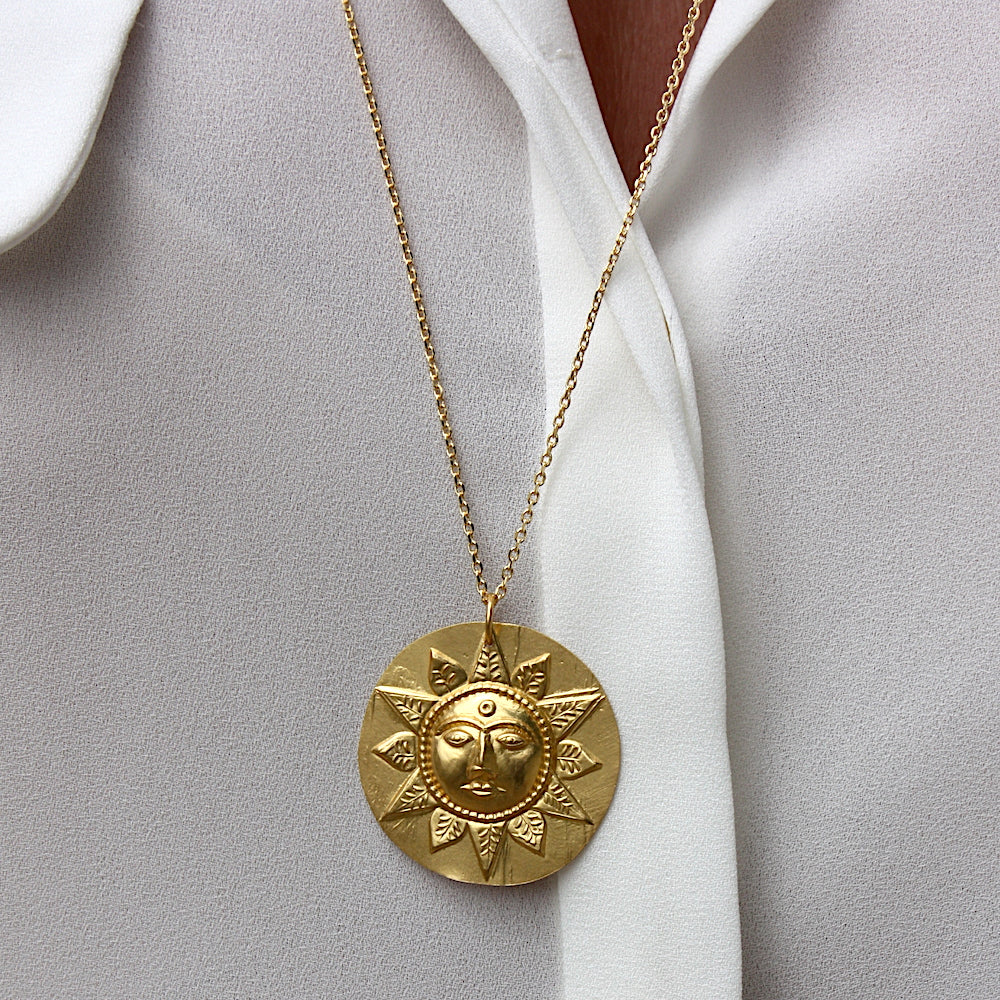 Collier doré et médaille mate soleil visage et feuilles