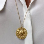 Collier doré et médaille mate soleil visage et feuilles