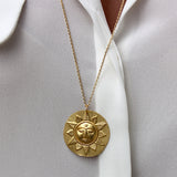 Collier doré et médaille mate soleil visage et feuilles