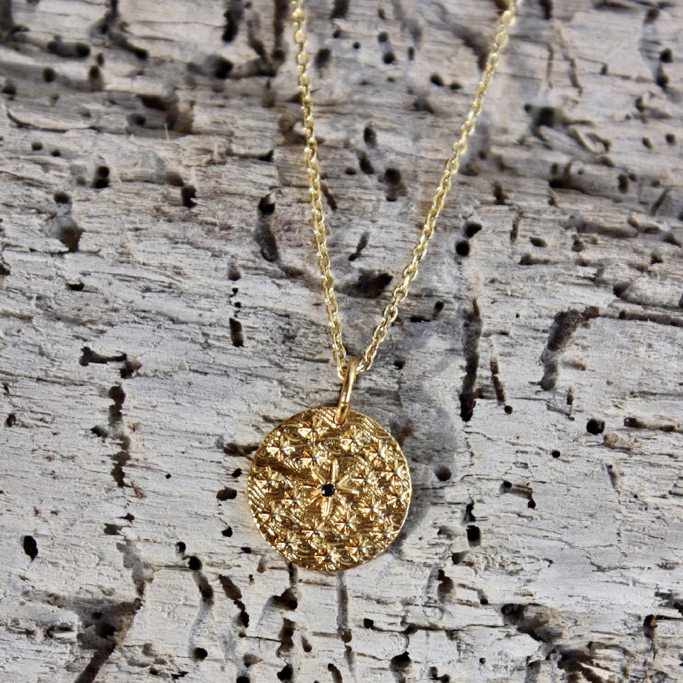 Collier doré médaille rose des vents et zircon