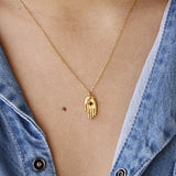 Gold open hand and zircon necklace