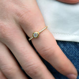 Golden ring with round stone and zircons