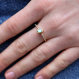 Golden ring with round stone and zircons